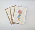 Hand-painted watercolour greeting card showing a small child in a blue coat and yellow stripy socks hidden behind a huge bouquet of blabberberries, with an ink border