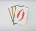Hand-painted watercolour greeting card featuring two red chilli peppers with ink spatter detail, shown with kraft envelopes